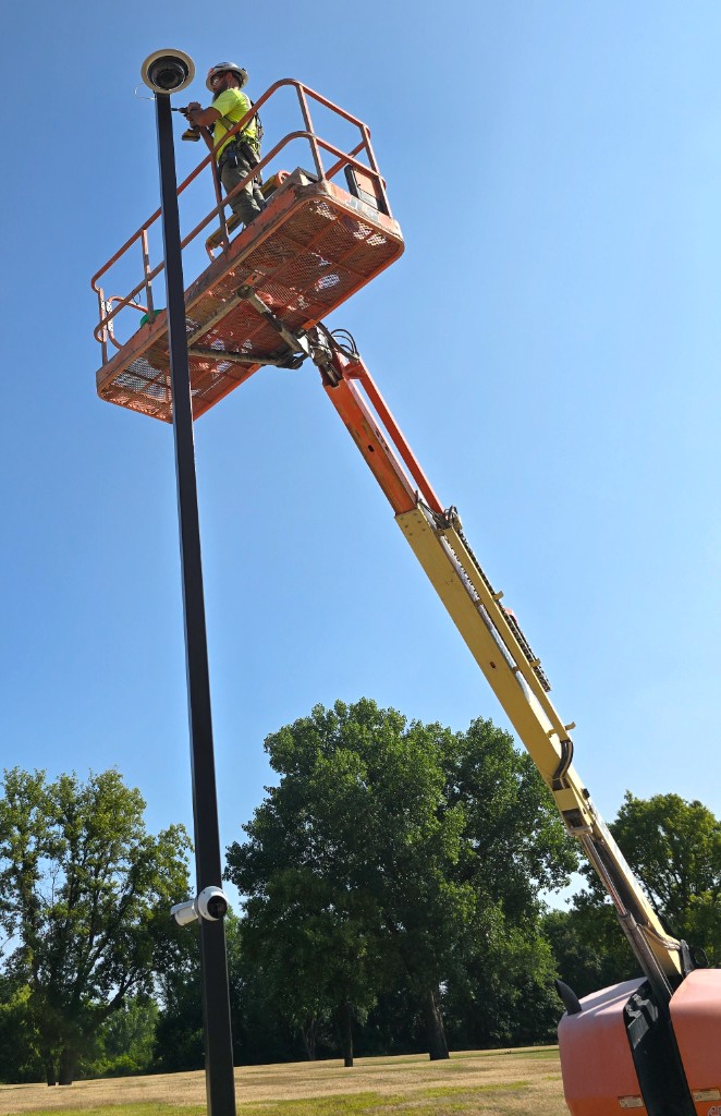 Canopy Vision technician installing a camera on a pole using an aerial lift at a rail yard